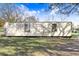 Exterior view of a long, metal storage container featuring two windows and a door, set in a grassy area at 31049 Eloian Dr, Wesley Chapel, FL 33545