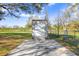 Back exterior view of a shed with double doors, featuring a concrete ramp and driveway at 31049 Eloian Dr, Wesley Chapel, FL 33545