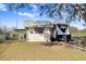 Quaint storage shed with a window and lean-to adjacent to an RV, set in a yard with scattered leaves at 31049 Eloian Dr, Wesley Chapel, FL 33545