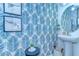 Stylish half bath featuring a patterned wallpaper, round mirror, and pedestal sink at 32960 Regent Canal St, Wesley Chapel, FL 33545