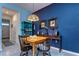 Cozy dining area with bright blue accent wall, wooden table, and pendant light at 32960 Regent Canal St, Wesley Chapel, FL 33545