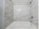 Bathroom featuring tub with marble-style tiled walls, offering a clean and contemporary look at 3620 E Shadowlawn Ave, Tampa, FL 33610
