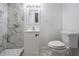 Modern bathroom features a marble tiled shower, vanity with sink, and toilet at 3620 E Shadowlawn Ave, Tampa, FL 33610