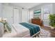 Cozy bedroom with a queen size bed, windows, and a dresser with a painting above at 3620 E Shadowlawn Ave, Tampa, FL 33610