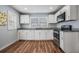 Modern kitchen features sleek white cabinets, stainless steel appliances, granite countertops, and stylish wood flooring at 3620 E Shadowlawn Ave, Tampa, FL 33610