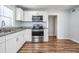 Bright kitchen with white cabinets, stainless steel appliances, granite countertops, and wood-look floors at 3620 E Shadowlawn Ave, Tampa, FL 33610