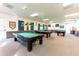 Spacious billiards room with multiple tables and traditional lighting fixtures at 36936 Kay Ave, Zephyrhills, FL 33542