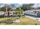 Charming yellow single-story home with red shutters, a driveway, and well-manicured landscaping at 36936 Kay Ave, Zephyrhills, FL 33542