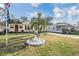 Shot of a home with mature palm tree and landscaped yard, plus patriotic ornamentation at 36936 Kay Ave, Zephyrhills, FL 33542