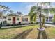 A charming home with a mature palm tree and landscaped garden beds, set on a well-maintained lawn at 36936 Kay Ave, Zephyrhills, FL 33542