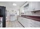 Well-maintained kitchen featuring white cabinets, black appliances, and a functional layout at 36936 Kay Ave, Zephyrhills, FL 33542