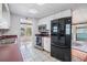 Traditional kitchen with white cabinets, black appliances, and tiled flooring at 36936 Kay Ave, Zephyrhills, FL 33542