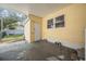 Covered patio with yellow siding, a white door, and access to the backyard at 36936 Kay Ave, Zephyrhills, FL 33542