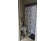 Bathroom with a toilet, a shower featuring a seashell shower curtain, and neutral tiling at 4355 Tahitian Gardens Cir # D, Holiday, FL 34691