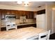 Cozy kitchen featuring an island, white appliances, and dark brown cabinetry at 4355 Tahitian Gardens Cir # D, Holiday, FL 34691