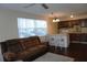 Open-concept living area with a kitchen island, modern lighting, and a comfortable sofa at 4355 Tahitian Gardens Cir # D, Holiday, FL 34691