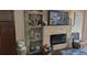 Cozy living room features a stone fireplace, built-in shelves, and a mounted television at 4355 Tahitian Gardens Cir # D, Holiday, FL 34691