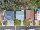 Aerial view of single-story homes with backyard landscaping and mature trees, in a residential neighborhood at 45 Gulfwinds W Dr, Palm Harbor, FL 34683