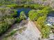 Stunning aerial view of a waterfront property with mature trees and a private pier leading to the tranquil water at 45 Gulfwinds W Dr, Palm Harbor, FL 34683
