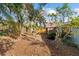 A spacious backyard with tropical trees, foliage, and a partial view of the house at 45 Gulfwinds W Dr, Palm Harbor, FL 34683