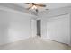 A neutral bedroom featuring a ceiling fan, closet, and an open doorway at 45 Gulfwinds W Dr, Palm Harbor, FL 34683
