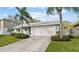 Inviting one-story home with two-car garage, mature landscaping, and a well-maintained lawn at 45 Gulfwinds W Dr, Palm Harbor, FL 34683