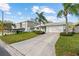 Charming single-story home with a well-manicured lawn, a long driveway, and a two-car garage at 45 Gulfwinds W Dr, Palm Harbor, FL 34683