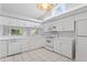 Bright kitchen with white appliances, tile flooring, and a decorative light fixture at 45 Gulfwinds W Dr, Palm Harbor, FL 34683