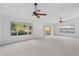 Spacious, well-lit living room with carpet, ceiling fan, and sliding doors to the exterior at 45 Gulfwinds W Dr, Palm Harbor, FL 34683