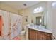 Bright bathroom featuring a single sink vanity and a shower with a floral curtain at 4524 Deep Creek Ter, Parrish, FL 34219
