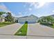 Charming home exterior featuring a spacious two-car garage and well-manicured landscaping with green grass and a blue sky at 4524 Deep Creek Ter, Parrish, FL 34219