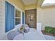 Charming covered front porch with seating and blue shuttered window, creating a welcoming entrance at 4524 Deep Creek Ter, Parrish, FL 34219
