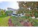 Landscaped front yard with vibrant flower beds and lush magnolia tree at 4524 Deep Creek Ter, Parrish, FL 34219