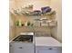 The laundry room has white, modern appliances with shelving above for storage at 4524 Deep Creek Ter, Parrish, FL 34219