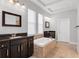 Primary bath with separate vanities, soaking tub with stone surround, and neutral walls at 5943 Jasper Glen Dr, Lithia, FL 33547