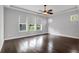 Spacious bedroom features a ceiling fan, dark hardwood floors, and bright windows at 5943 Jasper Glen Dr, Lithia, FL 33547