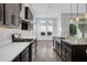 Well-appointed kitchen with stainless appliances, dark cabinetry, granite countertops, and hardwood floors at 5943 Jasper Glen Dr, Lithia, FL 33547