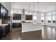 Spacious kitchen with hardwood floors, a large island, dark cabinets, and stainless steel appliances at 5943 Jasper Glen Dr, Lithia, FL 33547