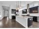 Modern kitchen with stainless steel appliances, a large island, granite countertops, and dark wood cabinetry at 5943 Jasper Glen Dr, Lithia, FL 33547