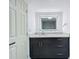 Modern bathroom vanity with marble-look countertop, dark cabinetry, and illuminated mirror at 6233 Dewdrop Way # 6233, Tampa, FL 33617