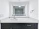 Bathroom vanity featuring a marble-look countertop, illuminated mirror, and dark cabinetry at 6233 Dewdrop Way # 6233, Tampa, FL 33617