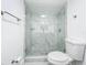 Modern bathroom featuring a marble-look tiled shower with glass doors, a toilet, and stylish fixtures at 6233 Dewdrop Way # 6233, Tampa, FL 33617