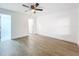 Spacious bedroom with light gray wood-look floors, white walls, a ceiling fan, and two entrance doors at 6233 Dewdrop Way # 6233, Tampa, FL 33617