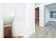 Hallway features light gray wood-look floors leading to a bedroom with a ceiling fan and natural light at 6233 Dewdrop Way # 6233, Tampa, FL 33617