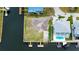 Aerial view of a waterfront lot with two docks alongside a home featuring a private pool, offering boating access at 7034 Southwind Dr, Hudson, FL 34667