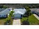 Overhead view showcasing a home with a two-car garage, palm trees, and a well-manicured lawn at 7034 Southwind Dr, Hudson, FL 34667