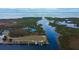 Breathtaking aerial view of waterfront property with a dock on canal leading to open water at 7034 Southwind Dr, Hudson, FL 34667
