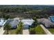 An aerial view of the quaint single story home with mature tropical landscaping, screened lanai, and neighborhood at 7034 Southwind Dr, Hudson, FL 34667