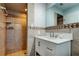 This bathroom has an updated vanity with a large mirror, updated tiling, and a walk-in shower at 7034 Southwind Dr, Hudson, FL 34667
