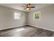 This bedroom is light and bright, with a ceiling fan, wood floors, and two windows at 7034 Southwind Dr, Hudson, FL 34667